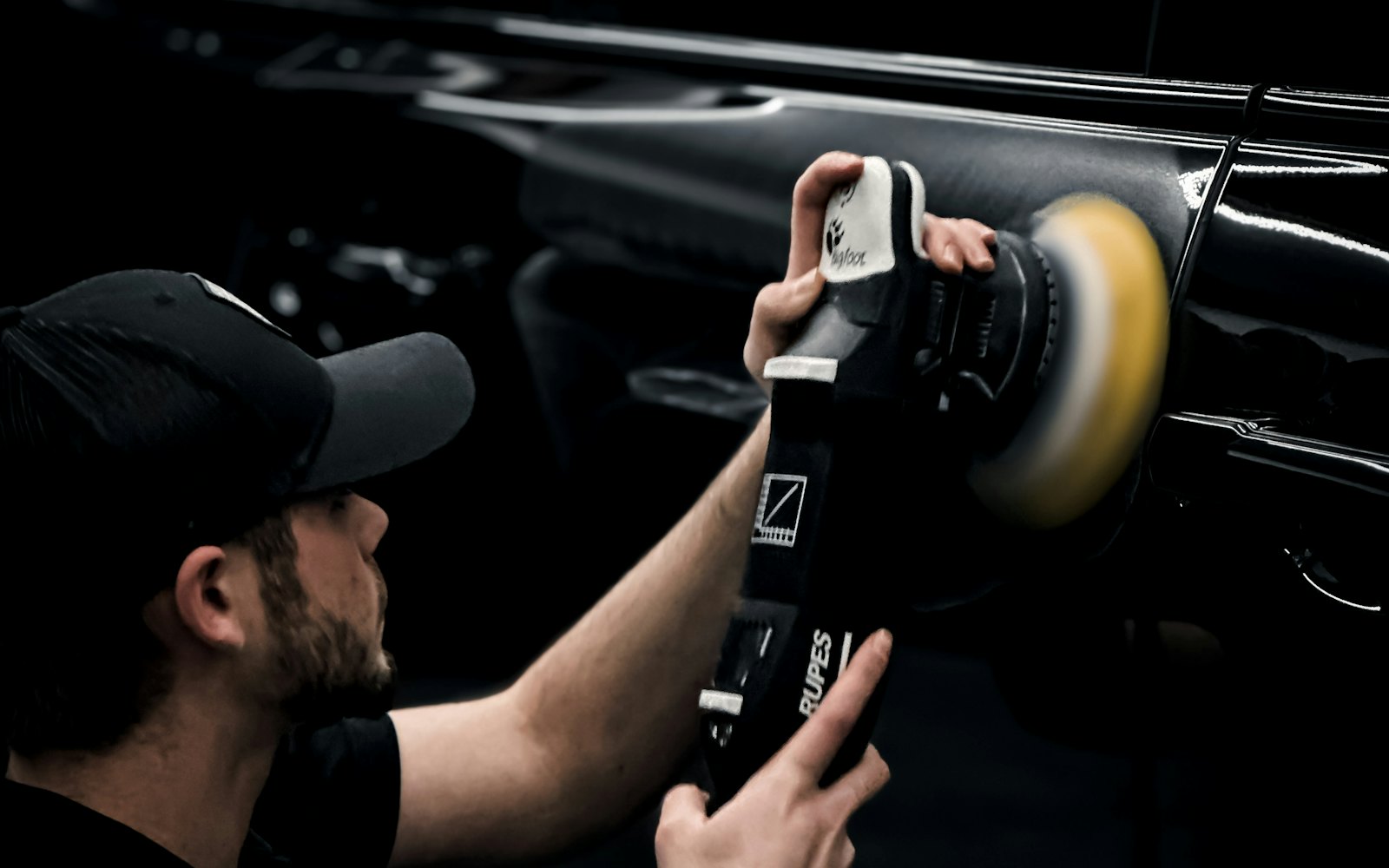 Detailer polishing a car