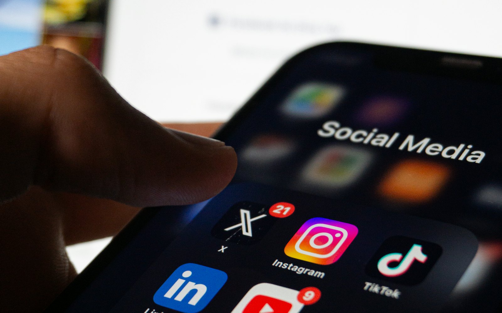 Hand holding a phone with social media apps