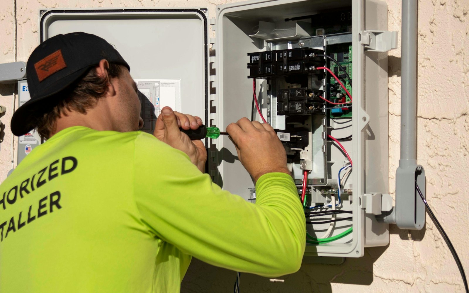 Electrician in hi-vis working on an electrical panel