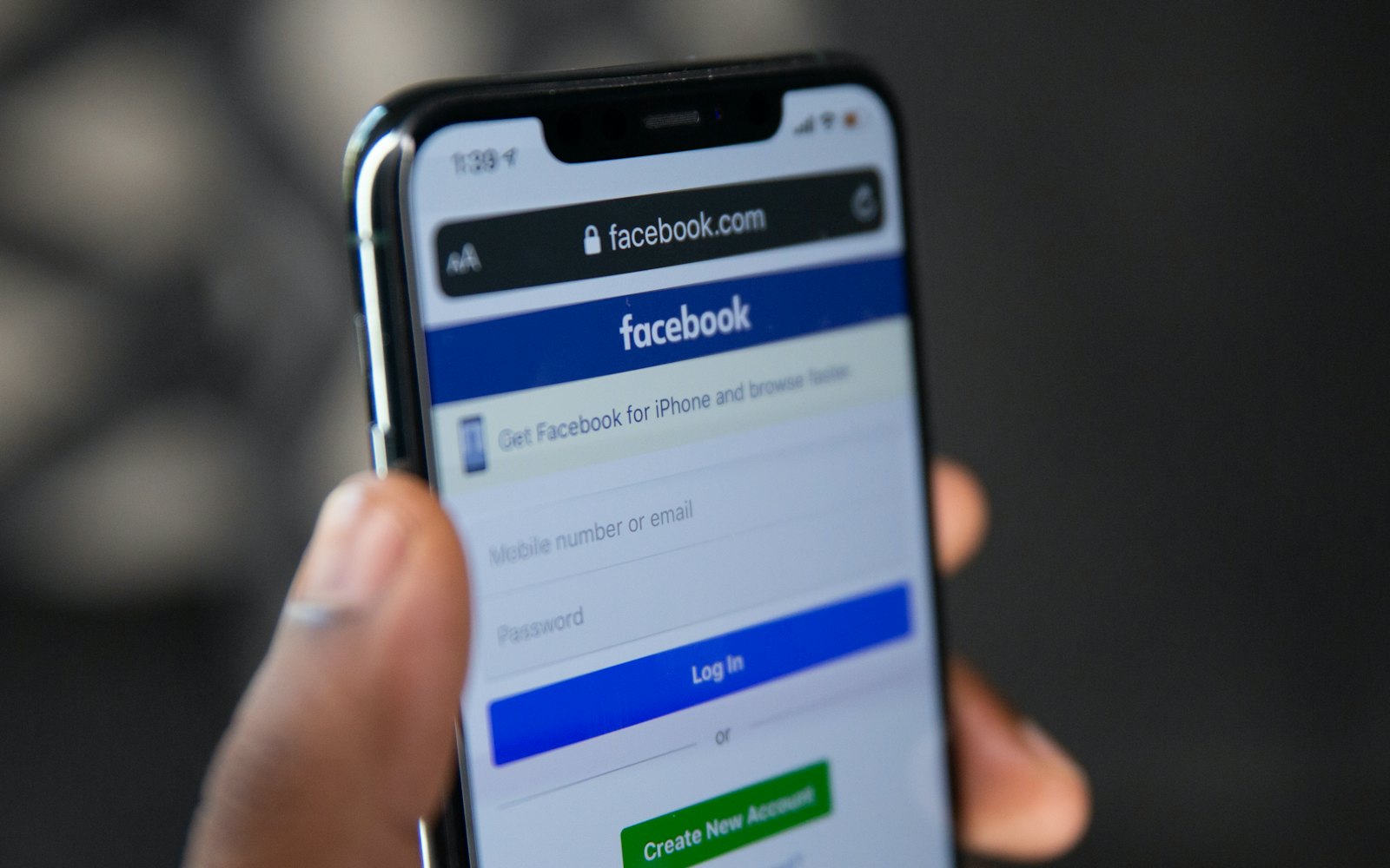 Hand holding a phone with Facebook open