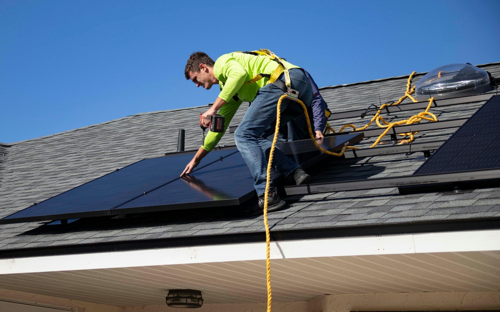 Installer fitting solar panels on a pitched roof